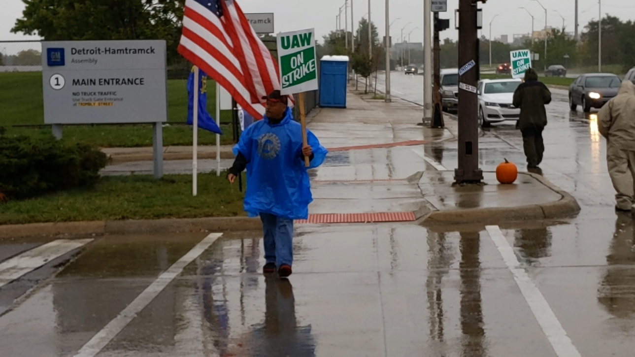 United Auto Workers on strike picket outside General Motors plant in cold rain