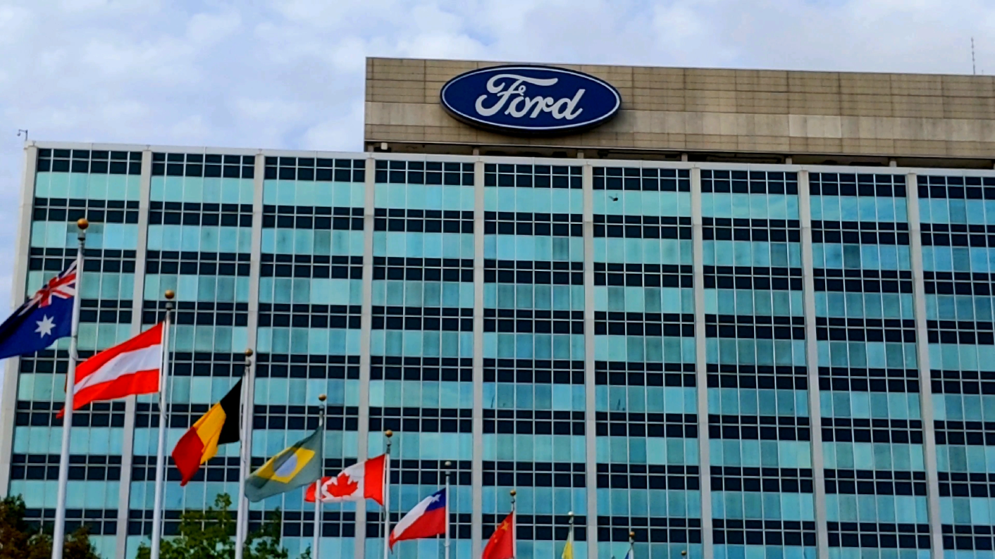 Zoom out of Henry Ford II World Center parking lot with international flags